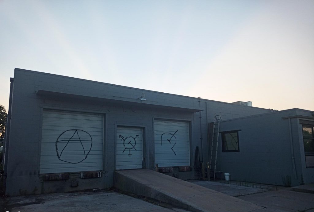 queersickle ancom logos spray painted - garage doors off 38th and walnut